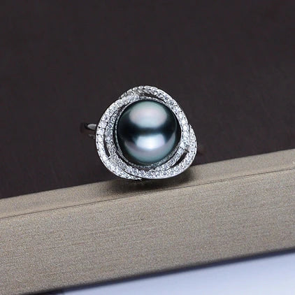Pearl ring with silver band on a dark background