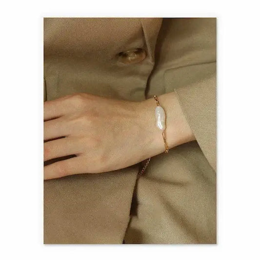 Baroque real pearl bracelet elegantly worn on a woman's wrist with a beige coat.