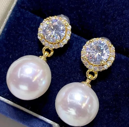 Pearl and diamond earrings on a dark blue velvet background
