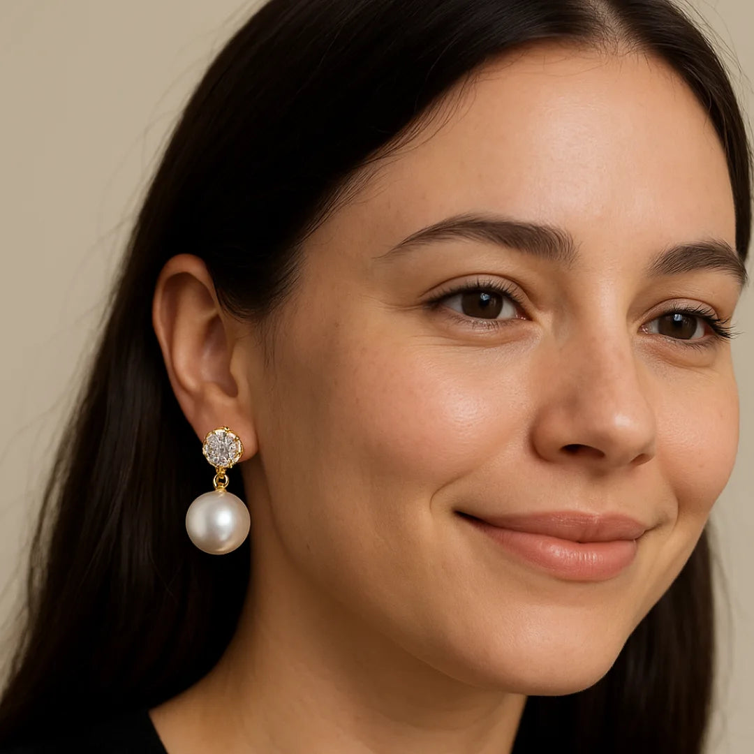 Close-up of a woman wearing pearl earrings with a neutral background