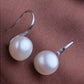Pearl earrings on a brown surface