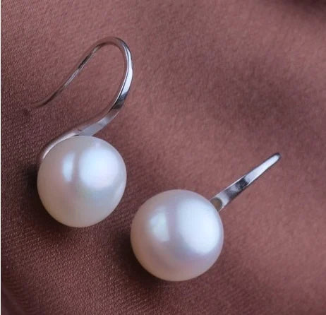 Pearl earrings on a brown surface