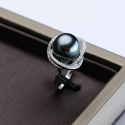 Pearl ring with silver band on a wooden surface