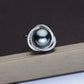 Pearl ring with silver band on a dark background