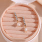 Pair of gold earrings with pearls in a pink jewelry box