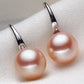 Pair of pink pearl earrings on a light gray background