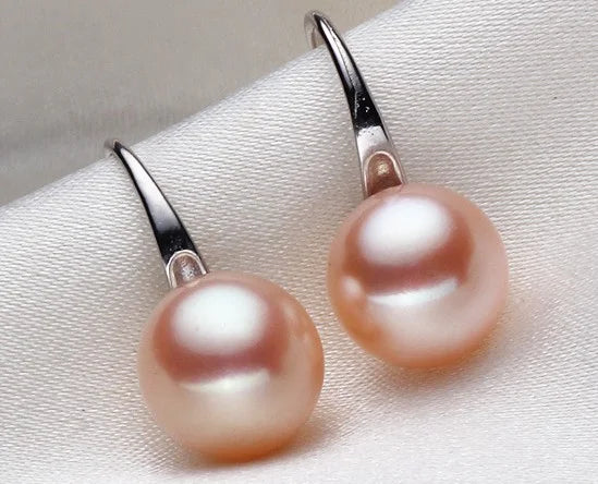 Pair of pink pearl earrings on a light gray background