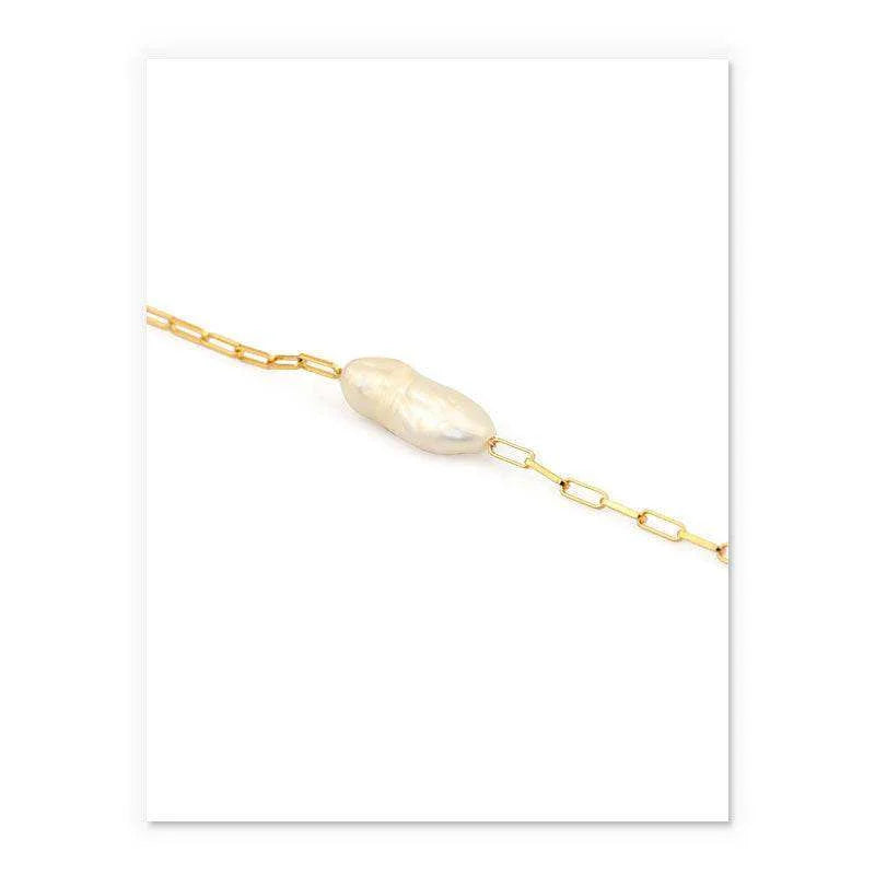 Gold bracelet with a single pearl on a white background