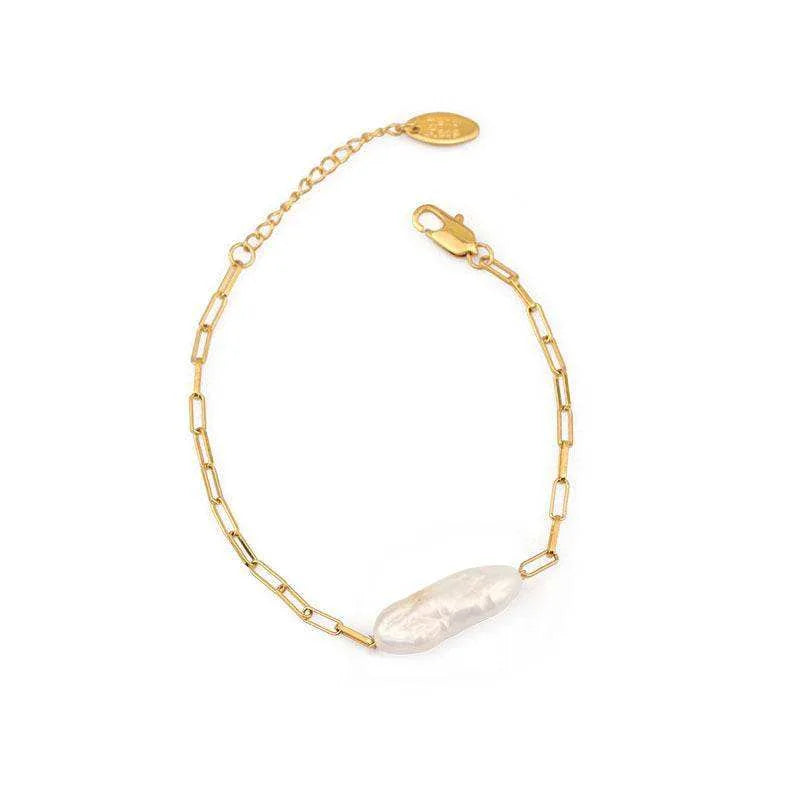 Gold bracelet with a pearl accent on a white background