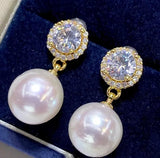 Pearl and diamond earrings on a dark blue velvet background