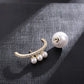 Pearl and gold brooch on a textured fabric background