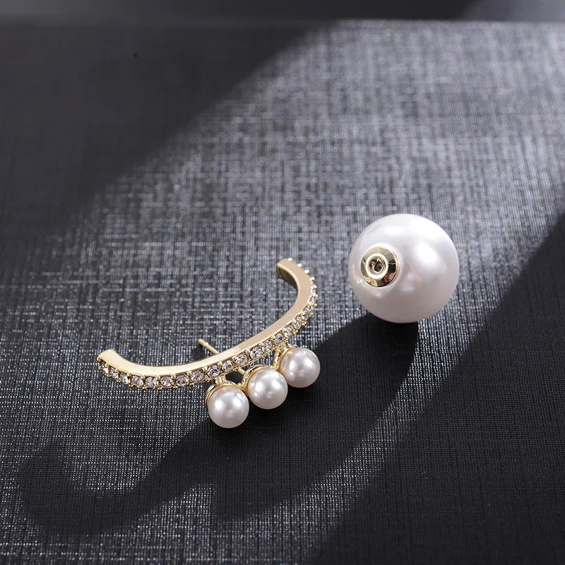 Pearl and gold brooch on a textured fabric background
