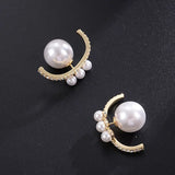 Pair of pearl earrings with gold accents on a black background