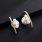 Pair of pearl earrings with gold accents on a black background