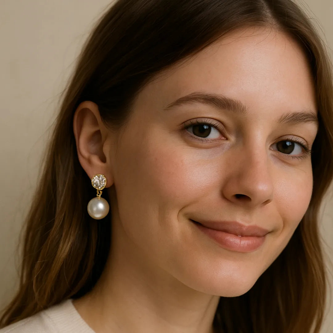 Close-up of a woman wearing pearl earrings against a neutral background