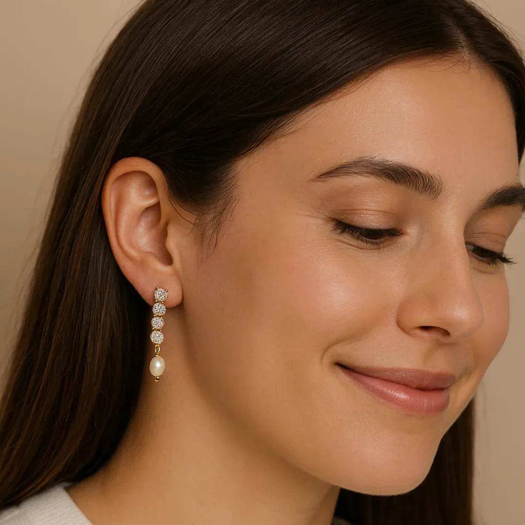 Close-up of a woman wearing a pearl earring with a neutral background