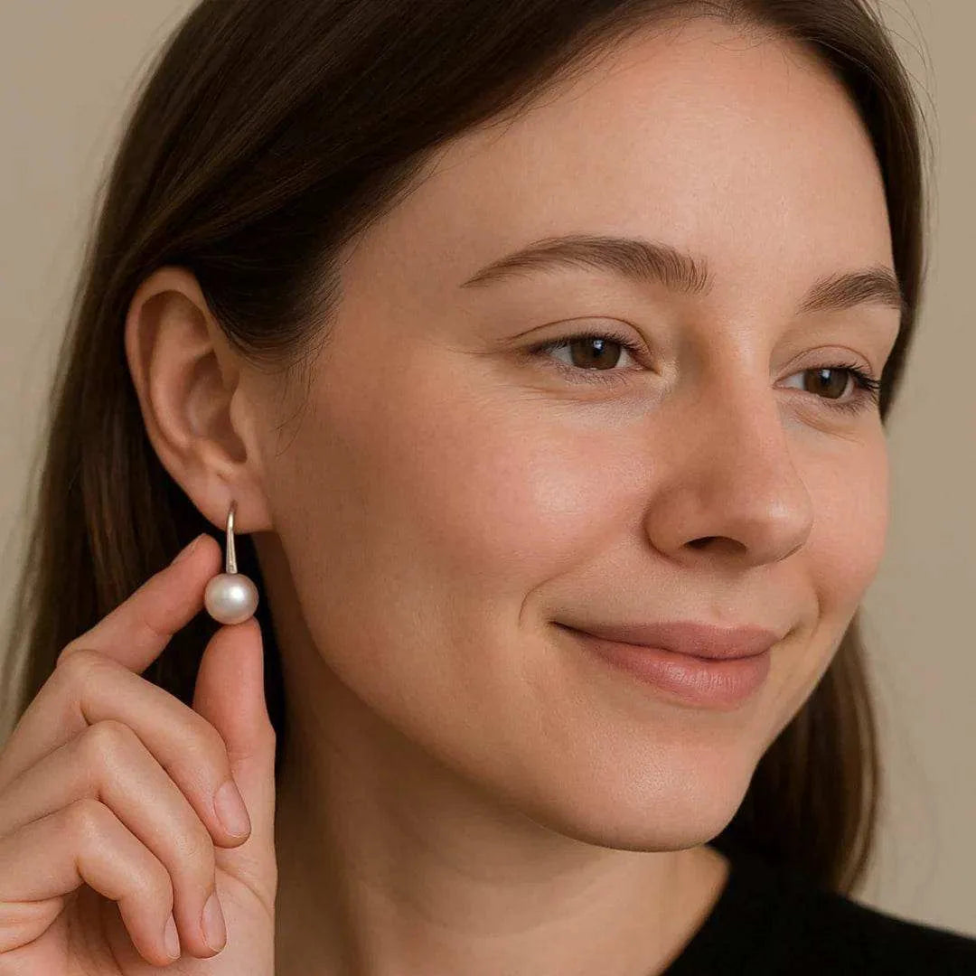 Woman wearing a pearl earring with a neutral background