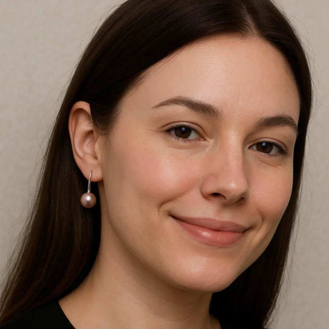 Woman wearing a pearl earring against a neutral background