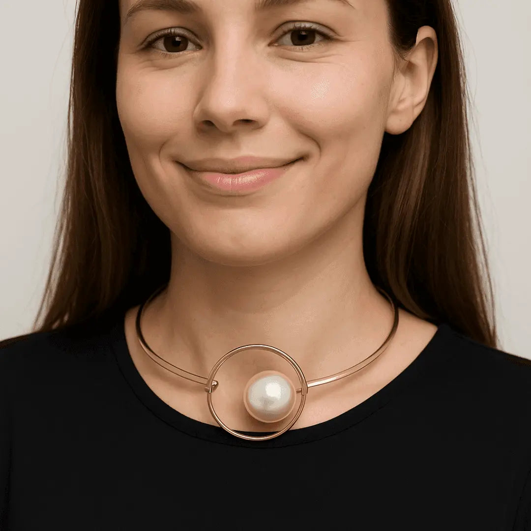Woman wearing a necklace with a large pearl pendant against a neutral background