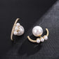 Pair of pearl earrings with gold accents on a dark textured surface